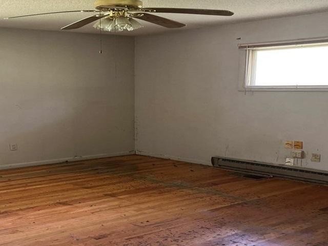 118 National Ave, Danville, IL 61832 - spare room with wood-type flooring, a baseboard radiator, ceiling fan, and a textured ceiling
