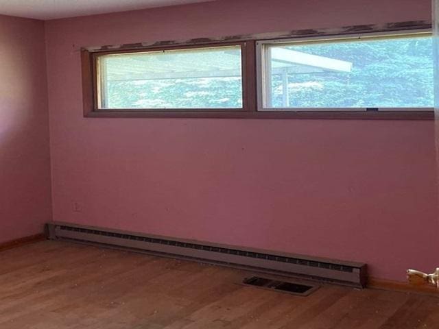 118 National Ave, Danville, IL 61832 - empty room featuring a baseboard heating unit and light wood finished floors