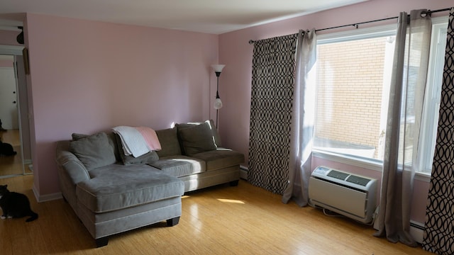 5704 W Montrose Ave Unit 2B, Chicago, IL 60634 - living area featuring light wood-style floors, an AC wall unit, and baseboard heating