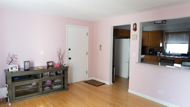 5704 W Montrose Ave Unit 2B, Chicago, IL 60634 - kitchen featuring light wood finished floors, freestanding refrigerator, brown cabinets, and tasteful backsplash