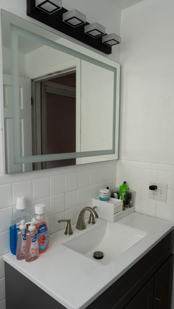 5704 W Montrose Ave Unit 2B, Chicago, IL 60634 - bathroom with vanity and tasteful backsplash