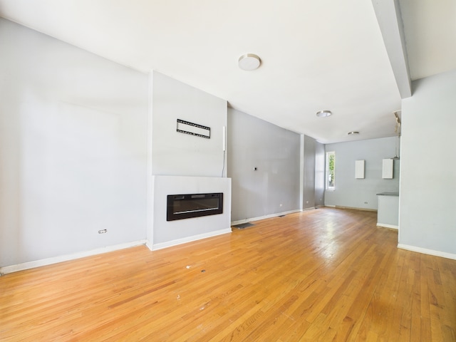 2933 W Wilcox St, Chicago, IL 60612 - unfurnished living room with light wood-type flooring and a glass covered fireplace