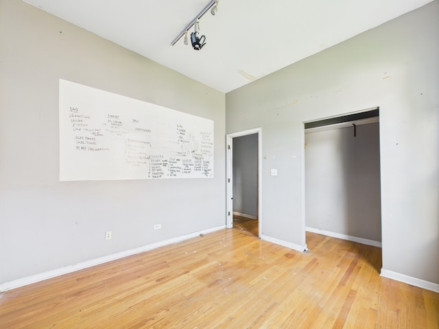 2933 W Wilcox St, Chicago, IL 60612 - unfurnished bedroom featuring light wood-type flooring, a closet, and rail lighting