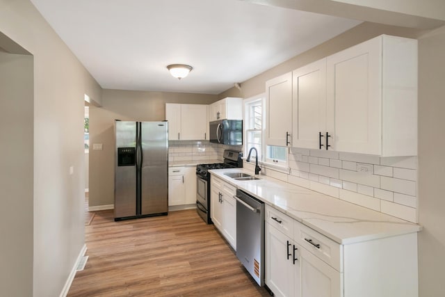 14348 Knox Ave, Midlothian, IL 60445 - kitchen featuring black appliances, decorative backsplash, light stone counters, light wood-style floors, and white cabinetry