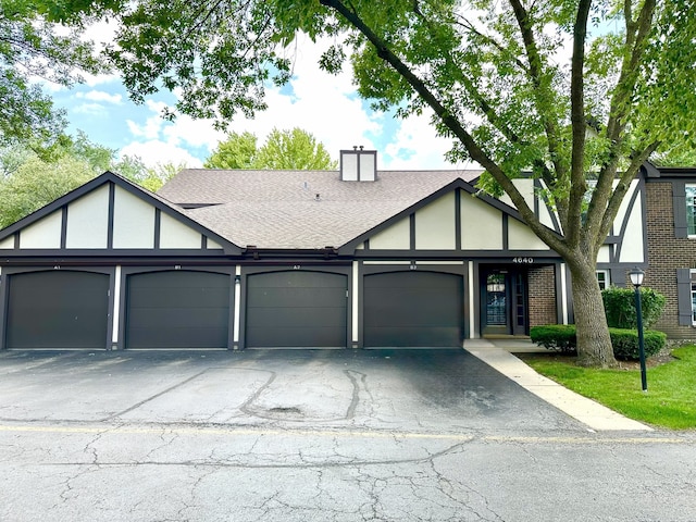 4640 Calvert Dr Unit B1, Rolling Meadows, IL 60008 - tudor home with an attached garage, roof with shingles, a chimney, and driveway