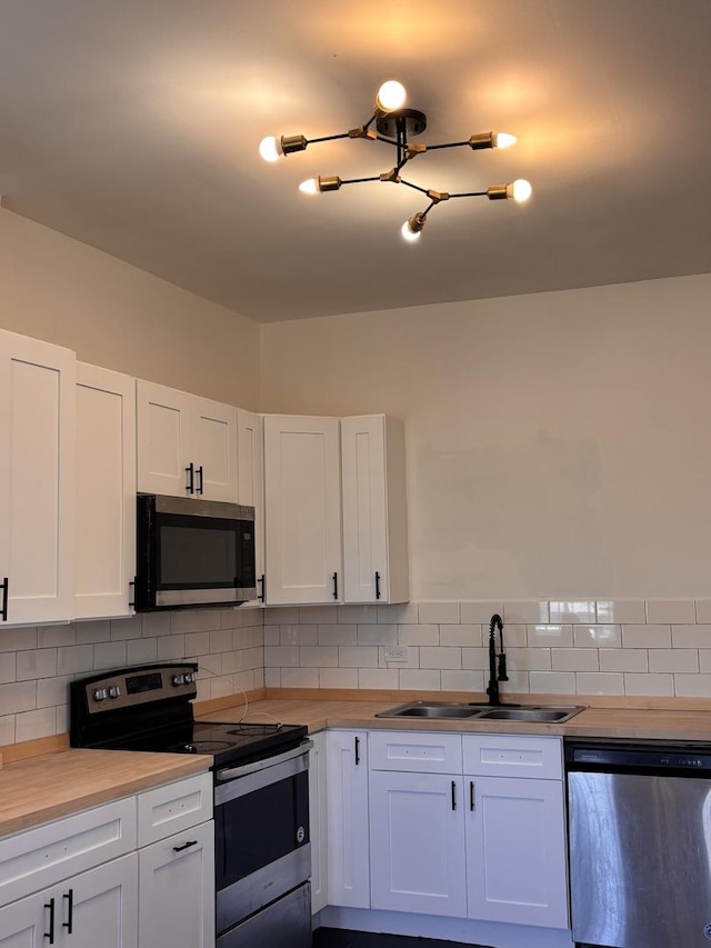 4138 W Adams St, Chicago, IL 60624 - kitchen with stainless steel appliances, white cabinets, and tasteful backsplash