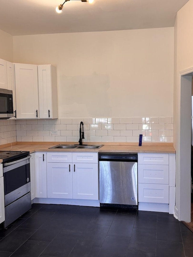 4138 W Adams St, Chicago, IL 60624 - kitchen with stainless steel appliances, white cabinets, backsplash, and wood counters