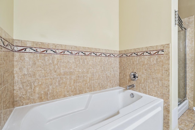 1740 N Maplewood Ave Unit 218, Chicago, IL 60647 - bathroom featuring a bath, a shower with shower door, tile walls, and wainscoting