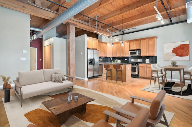 1740 N Maplewood Ave Unit 218, Chicago, IL 60647 - living area with a wooden ceiling with exposed beams, light wood-style flooring, rail lighting, and a high ceiling