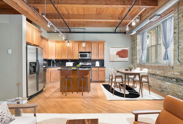 1740 N Maplewood Ave Unit 218, Chicago, IL 60647 - kitchen with appliances with stainless steel finishes, a wooden ceiling with exposed beams, brick wall, rail lighting, and light wood-style floors