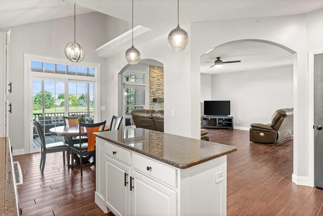 2913 Fox Creek Rd, Bloomington, IL 61705 - kitchen featuring arched walkways, dark wood finished floors, ceiling fan, a center island, and a high ceiling