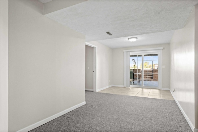 2913 Fox Creek Rd, Bloomington, IL 61705 - unfurnished room with light carpet, a textured ceiling, and light tile patterned floors