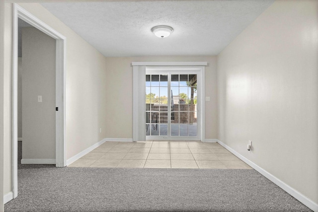 2913 Fox Creek Rd, Bloomington, IL 61705 - empty room featuring light carpet, light tile patterned floors, and a textured ceiling