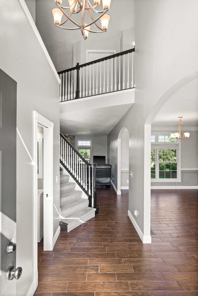2913 Fox Creek Rd, Bloomington, IL 61705 - entrance foyer featuring a chandelier, arched walkways, a high ceiling, wood finished floors, and stairs