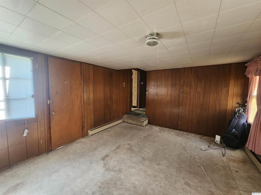 525 Chestnut, Quincy, IL 62301 - empty room with a baseboard heating unit, wooden walls, and light carpet