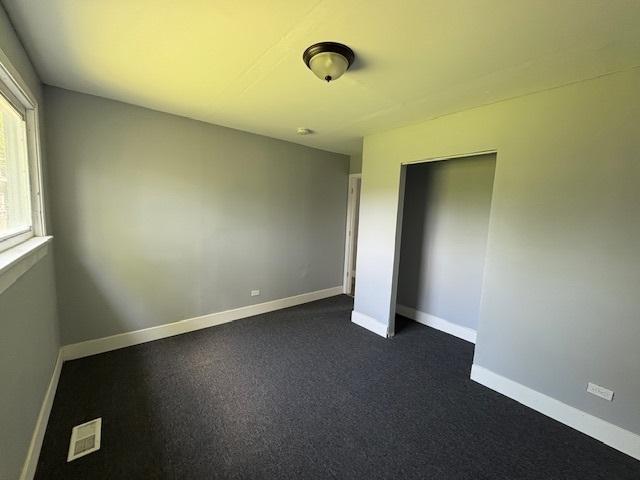 1946 Dartmouth St, Chicago Heights, IL 60411 - unfurnished bedroom with baseboards and dark carpet
