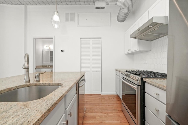 1645 W School St Unit 318, Chicago, IL 60657 - kitchen with appliances with stainless steel finishes, exhaust hood, light wood-type flooring, white cabinetry, and pendant lighting