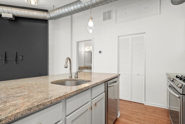 1645 W School St Unit 318, Chicago, IL 60657 - kitchen featuring stainless steel appliances, light wood finished floors, light stone countertops, white cabinets, and pendant lighting