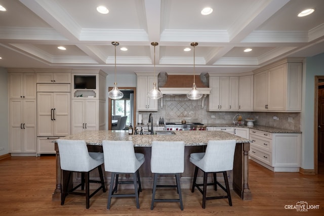 4211 Legend Ct, Naperville, IL 60564 - kitchen featuring paneled built in refrigerator, coffered ceiling, range hood, a kitchen island with sink, and a breakfast bar