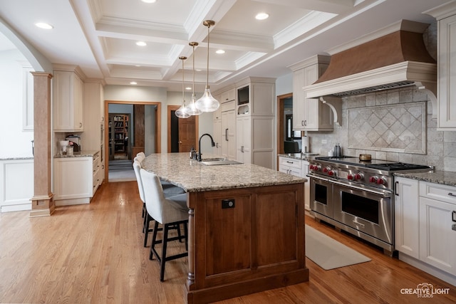 4211 Legend Ct, Naperville, IL 60564 - kitchen featuring double oven range, custom exhaust hood, beam ceiling, a kitchen island with sink, and coffered ceiling