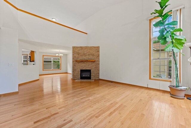 10578 Harrison Ct, Roscoe, IL 61073 - unfurnished living room with high vaulted ceiling, light wood finished floors, a chandelier, and a fireplace