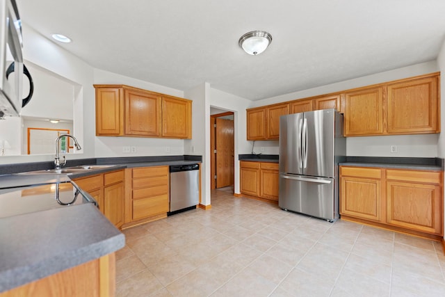 10578 Harrison Ct, Roscoe, IL 61073 - kitchen with appliances with stainless steel finishes, dark countertops, light tile patterned flooring, and brown cabinetry