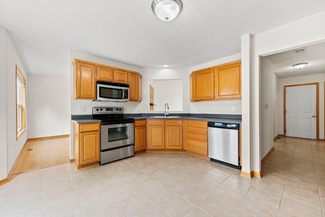 10578 Harrison Ct, Roscoe, IL 61073 - kitchen featuring appliances with stainless steel finishes, dark countertops, and light tile patterned floors