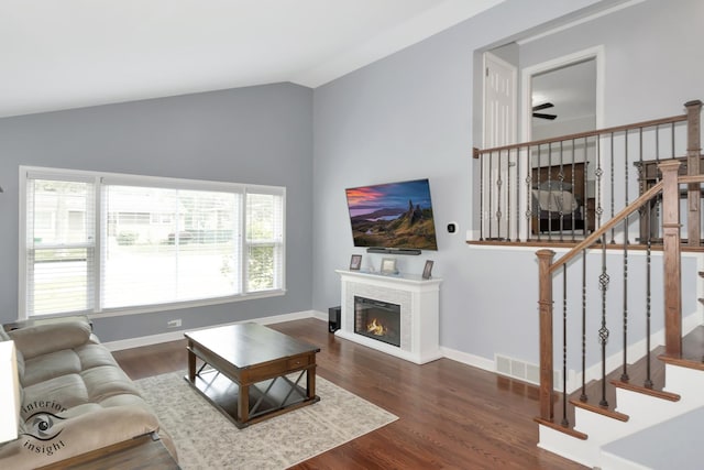 7027 174th Pl, Tinley Park, IL 60477 - living room with a warm lit fireplace, lofted ceiling, wood finished floors, ceiling fan, and stairway