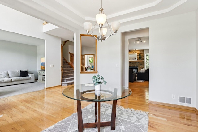 1271 Mcdole Dr, Sugar Grove, IL 60554 - dining space with light wood finished floors, stairway, a raised ceiling, a fireplace, and a chandelier