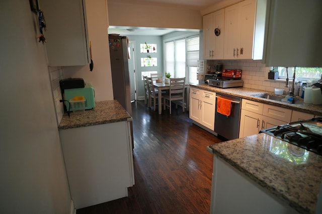 3321 W 71st St, Chicago, IL 60629 - kitchen with stainless steel dishwasher, white cabinetry, dark wood-type flooring, and backsplash