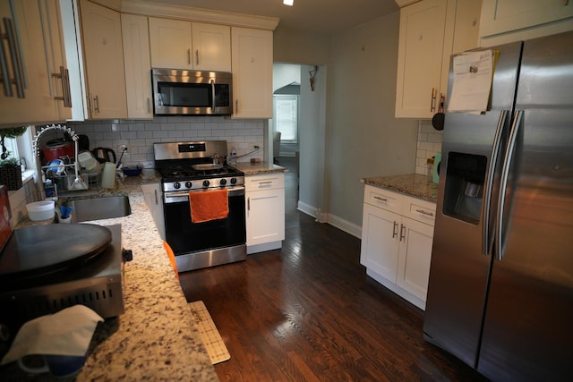 3321 W 71st St, Chicago, IL 60629 - kitchen featuring appliances with stainless steel finishes, tasteful backsplash, dark wood finished floors, and light stone countertops