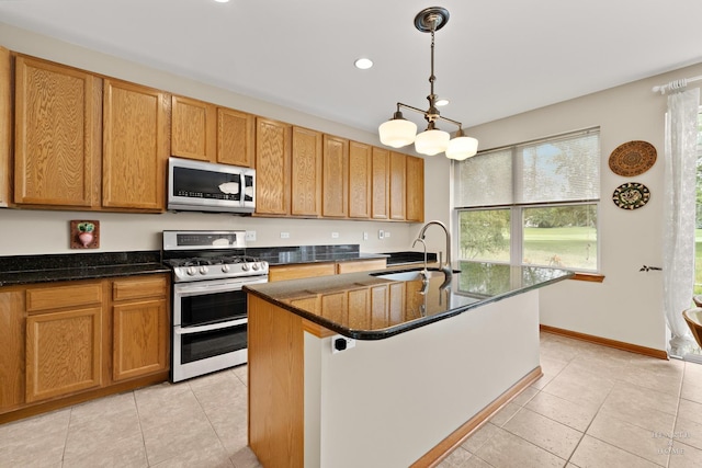 365 Oakmont Dr, Cary, IL 60013 - kitchen with stainless steel appliances, light tile patterned floors, recessed lighting, a kitchen island with sink, and hanging light fixtures