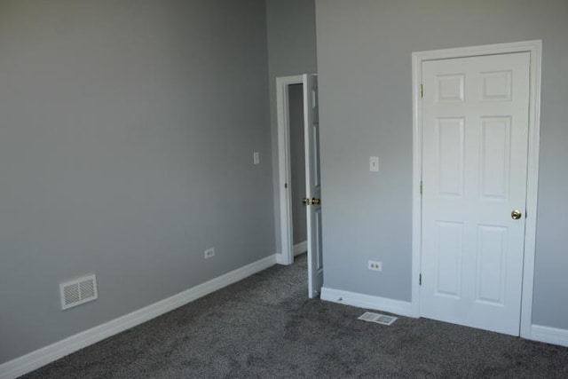 43 E 145th St, Harvey, IL 60426 - unfurnished bedroom with dark colored carpet and baseboards