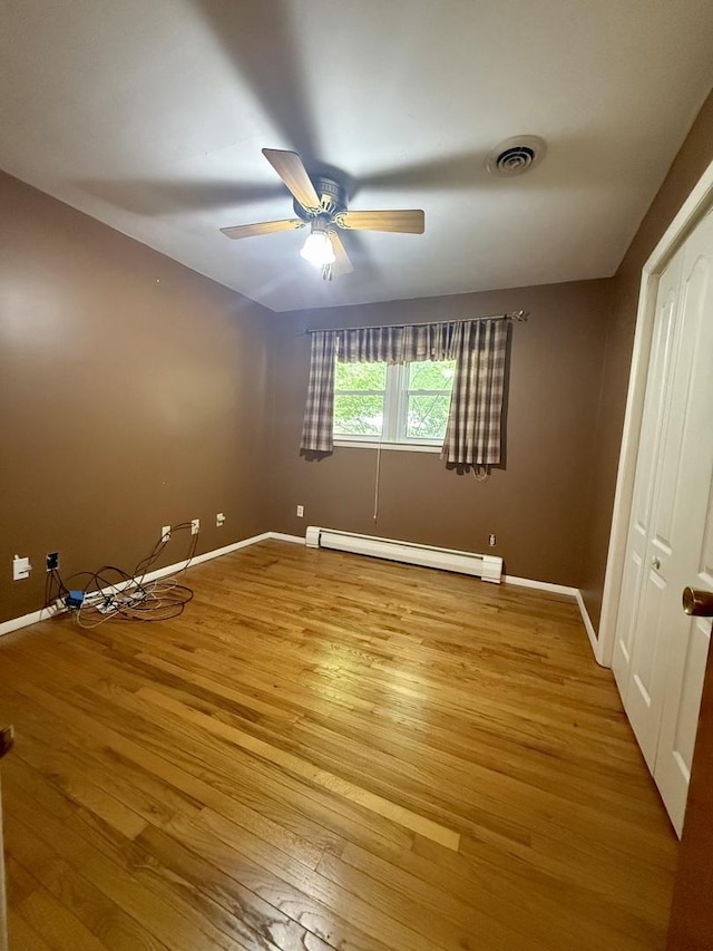 1340 Jeffrey Dr, Rantoul, IL 61866 - unfurnished room featuring a baseboard radiator, light wood-style floors, and ceiling fan
