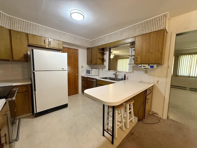 1340 Jeffrey Dr, Rantoul, IL 61866 - kitchen with appliances with stainless steel finishes, tasteful backsplash, brown cabinetry, and a kitchen bar