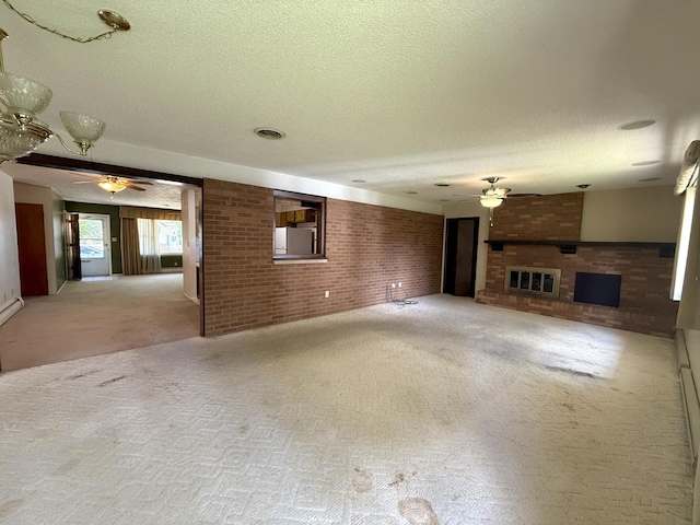 1340 Jeffrey Dr, Rantoul, IL 61866 - unfurnished living room with ceiling fan, brick wall, a textured ceiling, carpet floors, and a brick fireplace