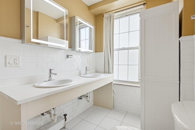 6101 N Sheridan Rd Unit 11C, Chicago, IL 60660 - bathroom featuring tile walls, tile patterned floors, wainscoting, and double vanity