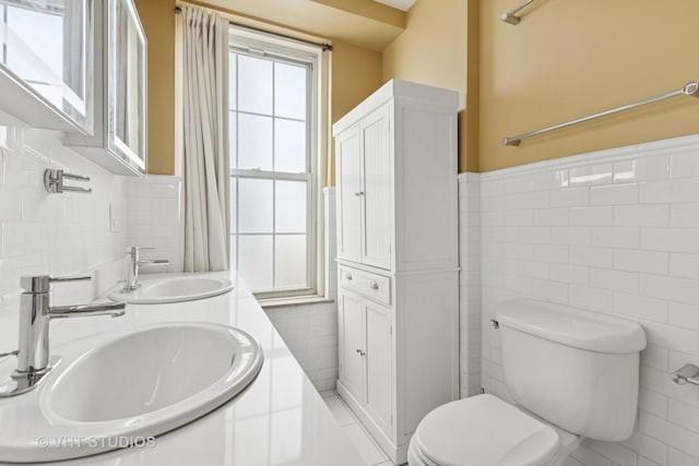 6101 N Sheridan Rd Unit 11C, Chicago, IL 60660 - full bath with tile walls, double vanity, a wainscoted wall, and tile patterned flooring