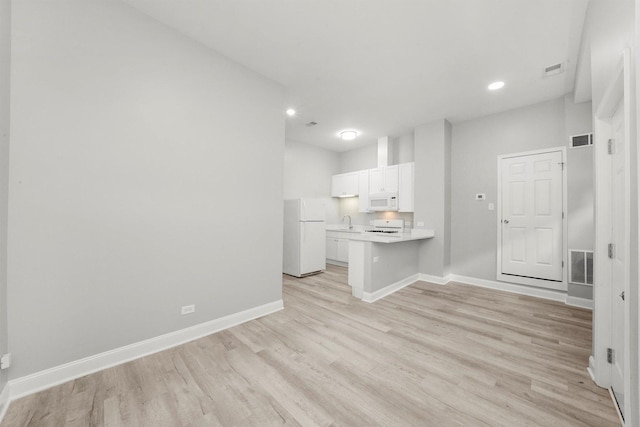 5401 W 22nd Pl, Cicero, IL 60804 - kitchen with white appliances, white cabinetry, a peninsula, light wood finished floors, and light countertops