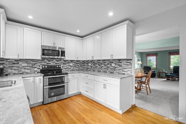 210 Fox Chase Dr N, Oswego, IL 60543 - kitchen with appliances with stainless steel finishes, white cabinetry, backsplash, recessed lighting, and light wood-style flooring