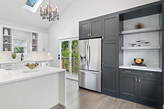 1116 W Addison St, Chicago, IL 60613 - kitchen featuring open shelves, stainless steel fridge, tasteful backsplash, light countertops, and dishwasher