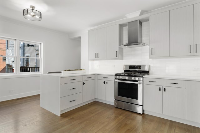 1116 W Addison St, Chicago, IL 60613 - kitchen featuring stainless steel gas range, wall chimney exhaust hood, a peninsula, light countertops, and tasteful backsplash