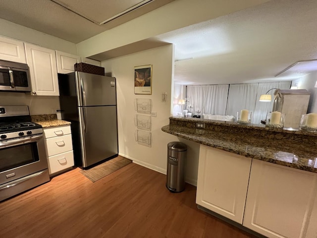 230 E Ontario St Unit 905, Chicago, IL 60611 - kitchen with stainless steel appliances, white cabinets, wood finished floors, and dark stone counters