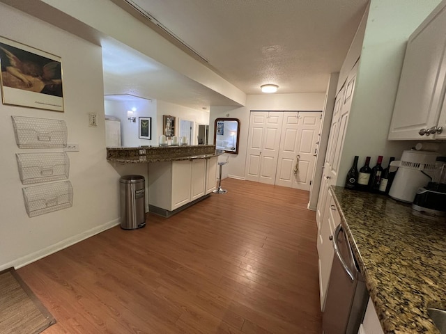 230 E Ontario St Unit 905, Chicago, IL 60611 - kitchen with dishwasher, wood finished floors, a peninsula, and dark stone countertops
