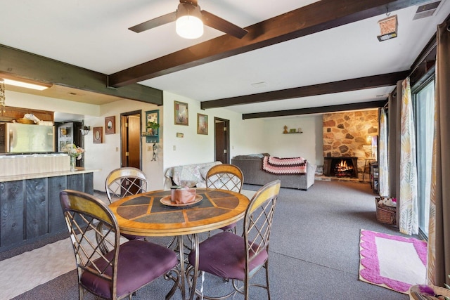 15810 Il Route 173 Unit 1D, Harvard, IL 60033 - dining space featuring carpet flooring, a ceiling fan, beamed ceiling, and a fireplace
