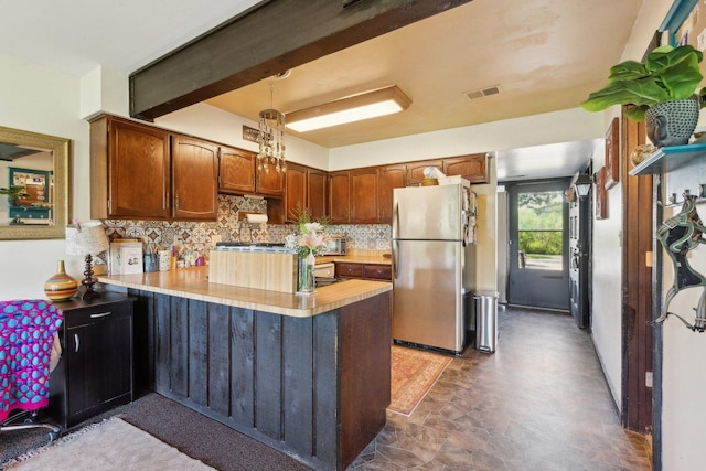 15810 Il Route 173 Unit 1D, Harvard, IL 60033 - kitchen with freestanding refrigerator, a peninsula, tasteful backsplash, light countertops, and brown cabinetry