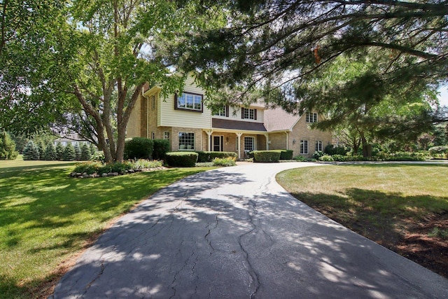 13 Wind Ridge Rd, South Barrington, IL 60010 - traditional home featuring a front lawn, driveway, stone siding, and a chimney