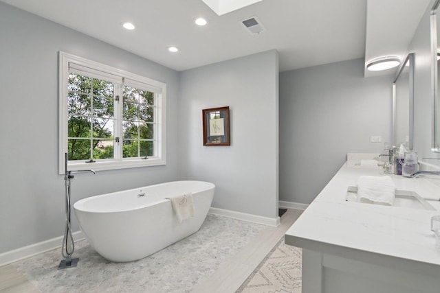 13 Wind Ridge Rd, South Barrington, IL 60010 - full bathroom featuring a freestanding tub, double vanity, recessed lighting, and a skylight
