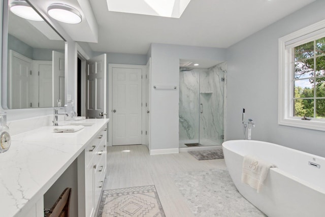 13 Wind Ridge Rd, South Barrington, IL 60010 - bathroom featuring a marble finish shower, vanity, a freestanding tub, a skylight, and recessed lighting