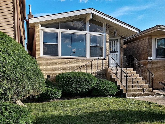 1747 E 92nd Pl, Chicago, IL 60617 - view of exterior entry with brick siding and a lawn
